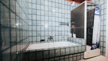 Łazienka z niebieskimi kafelkami, kabiną prysznicową i wanną